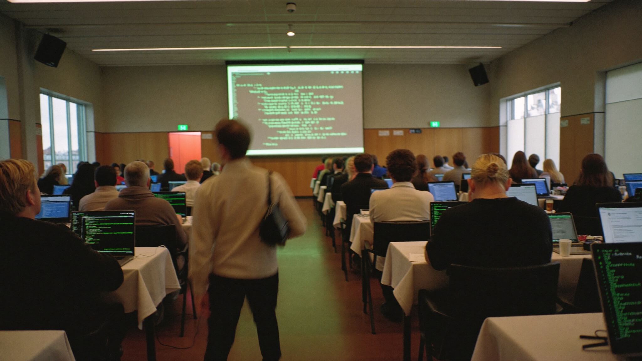 A workshop session with code projected in a lecture hall
