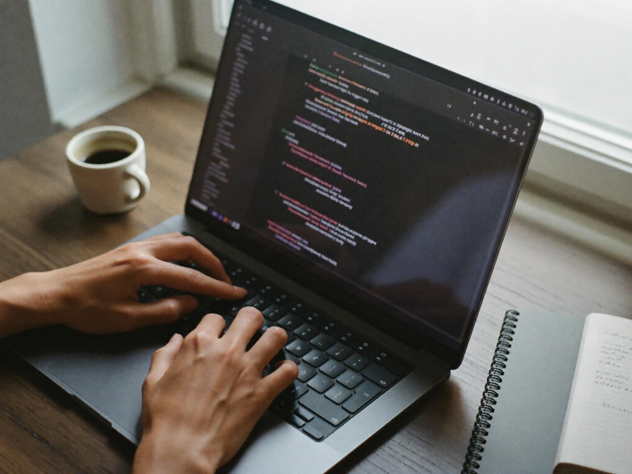 Hands typing on a laptop keyboard