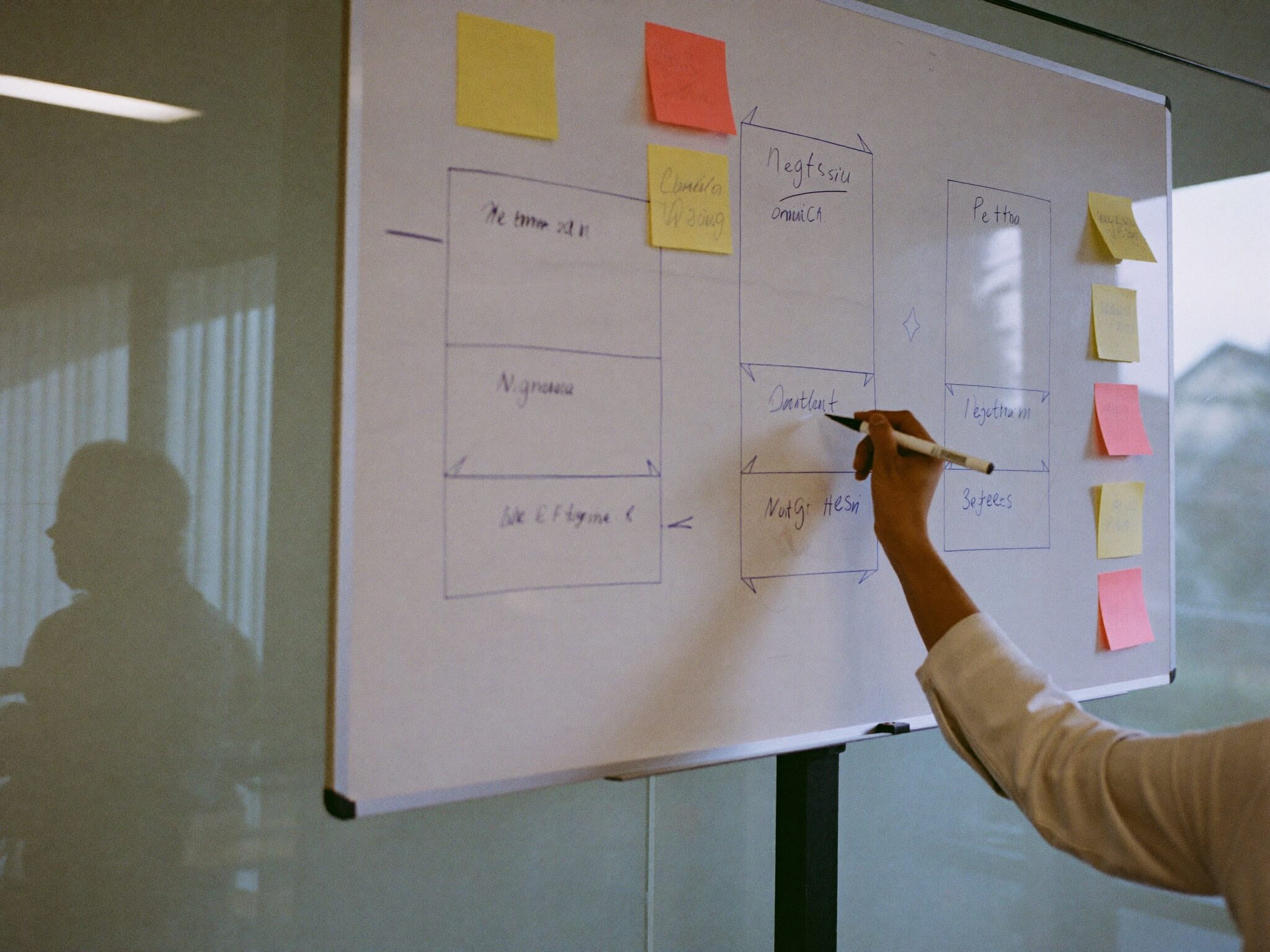 An engineer sketching a plan on a whiteboard